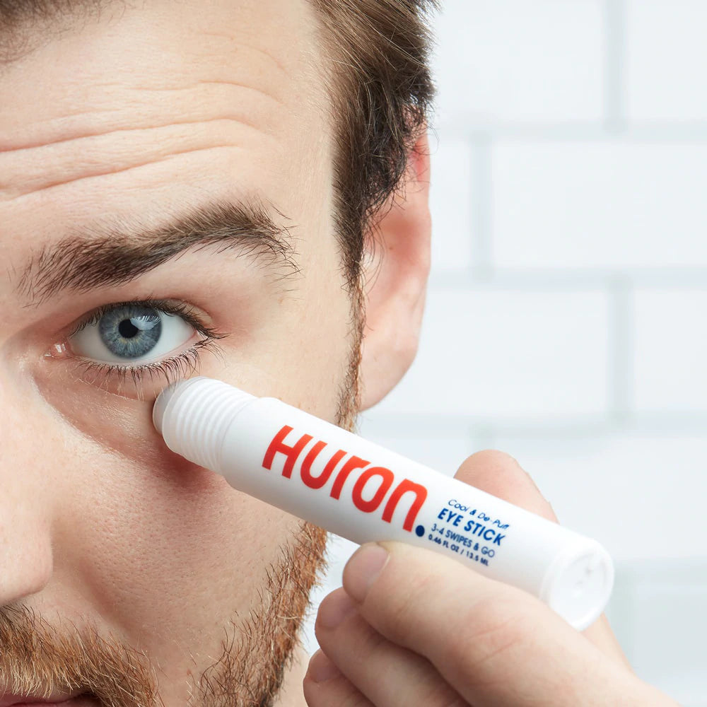 A man applies the Eye Stick product to his under eye area. 